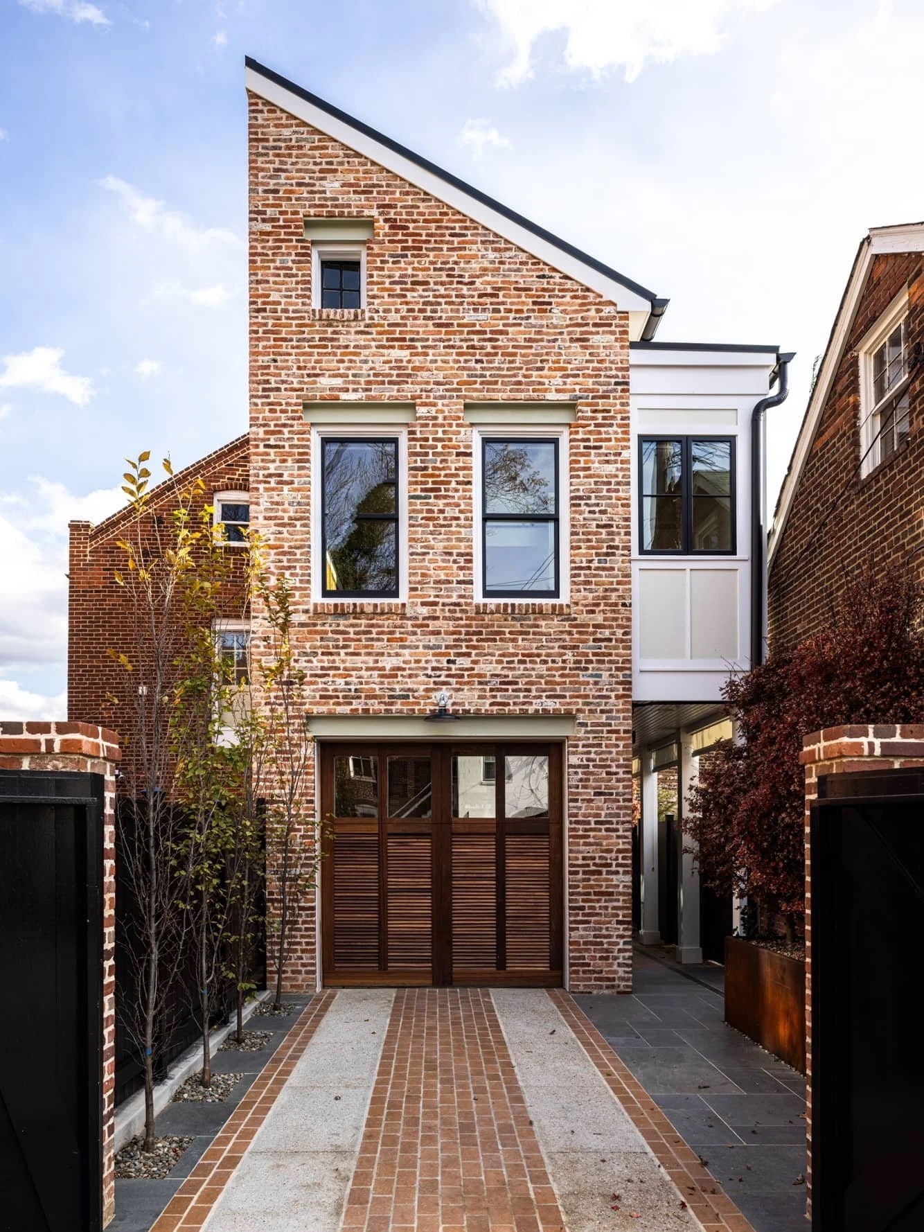 Small brick building with black windows and a wood door